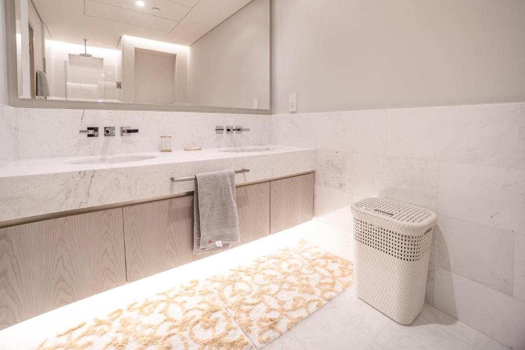 迪拜Palm Tower Palm Jumeirah Dubai的浴室设有水槽、镜子和地毯。