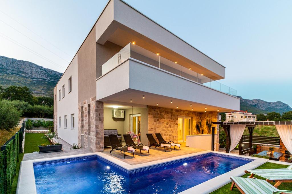 卡什泰拉Villa Olea-with pool, sea view, near Split airport的房屋前有游泳池的房子