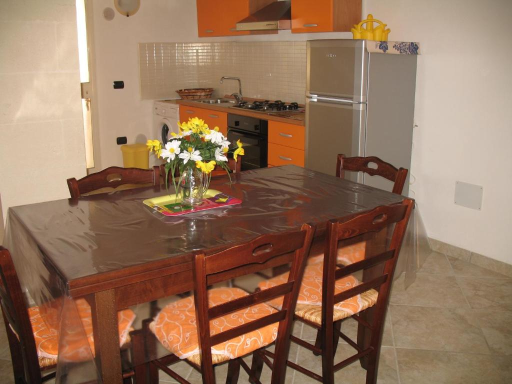 托雷奥沃Casa Salento Mare的厨房配有一张桌子,上面放着花瓶