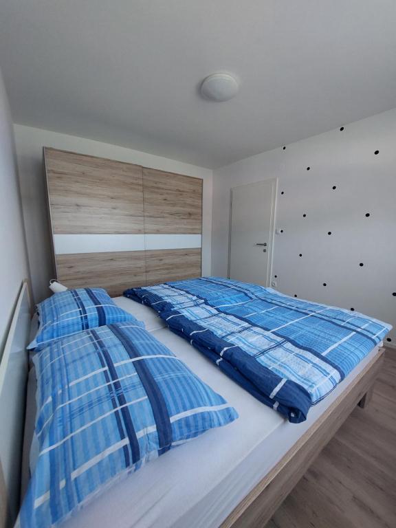 克拉尼斯卡戈拉Apartments Marica的一间卧室配有一张带蓝色和白色枕头的床