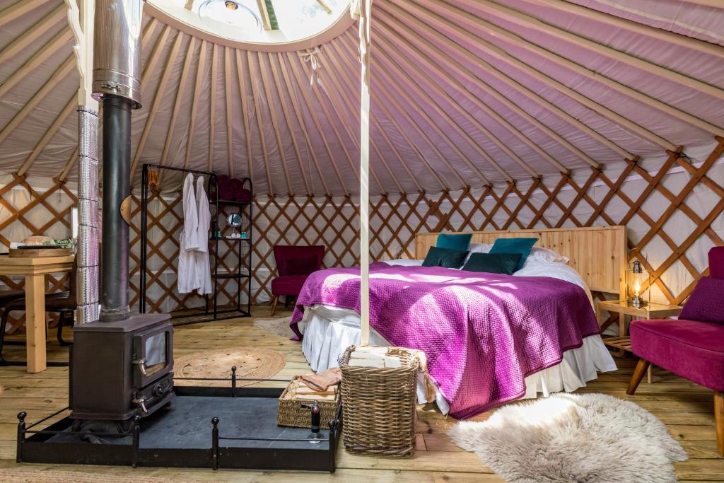 巴克斯顿Luxury Yurt with Hot Tub - pre-heated for your arrival的蒙古包内一间卧室配有一张床和一个炉灶