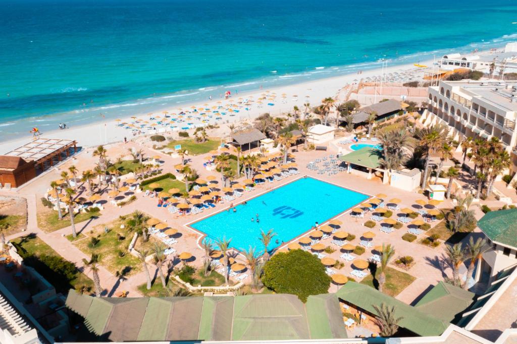 DjerbaVincci Dar Midoun的享有带游泳池和海滩的度假村的空中景致