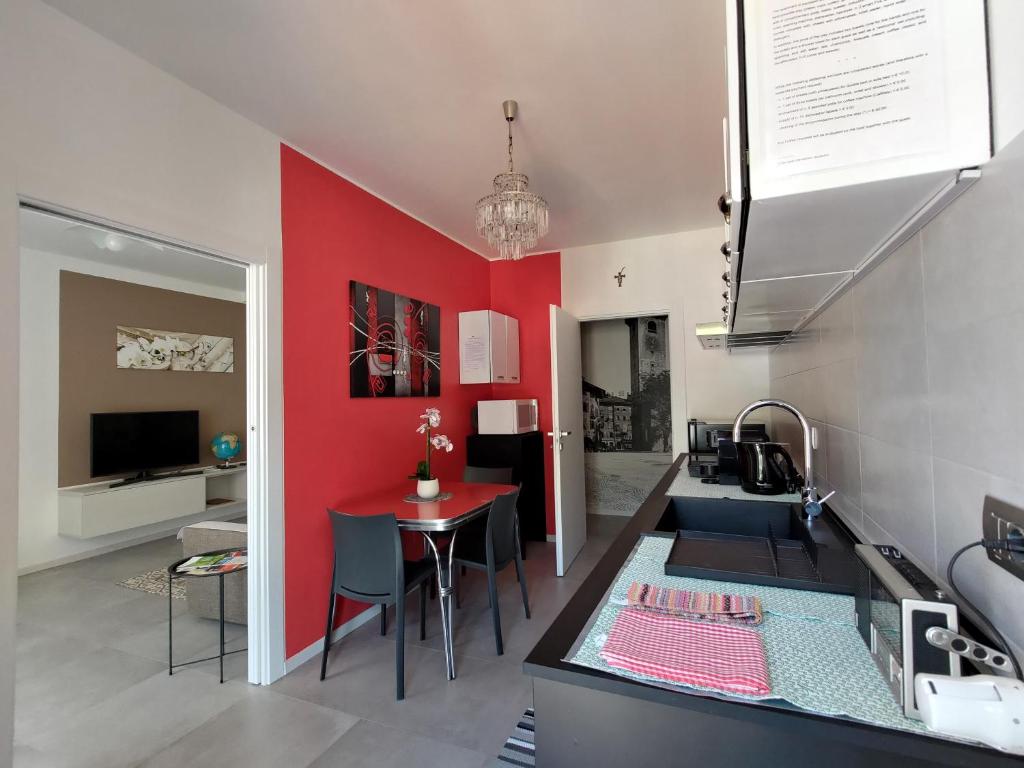 特伦托Design apartment n. 41的一间红色墙和一张桌子的厨房
