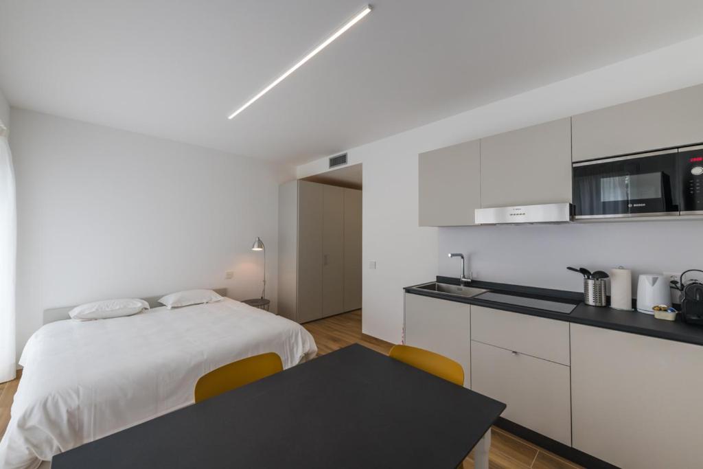 门德里西奥Modern Studios Mendrisio的白色卧室配有床和黑桌