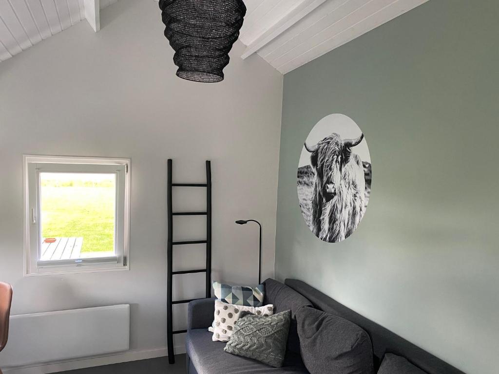 哈伦Blokhut Klein Meerzicht的客厅配有沙发,墙上挂着一幅公牛的照片