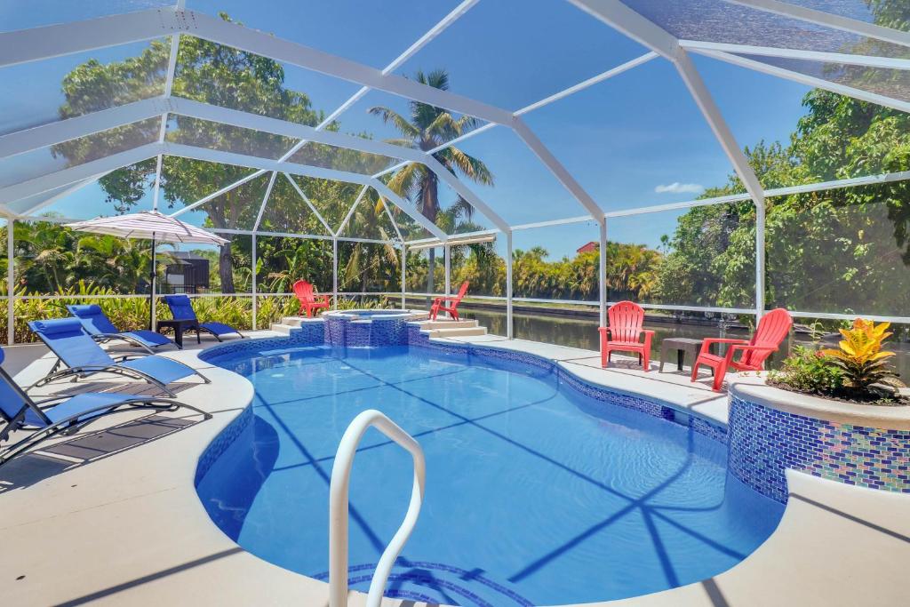 珊瑚角Waterfront Pool Villa with Sailboat access的一个带椅子的大型游泳池