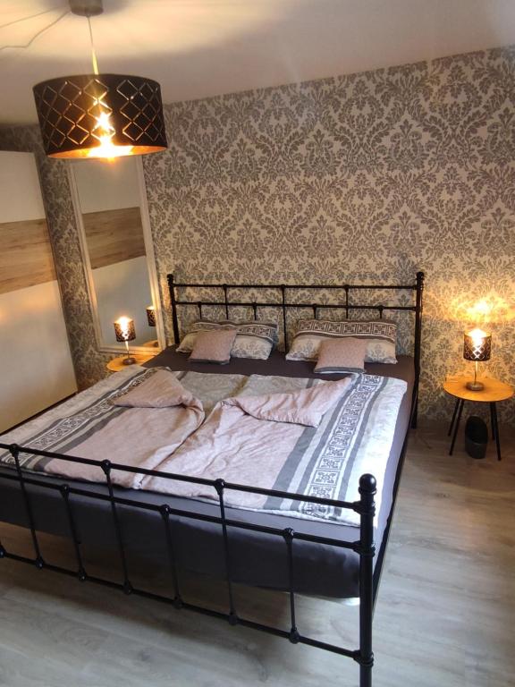 圣温德尔Zum Buchenblick的卧室内的一张大床,配有两盏灯