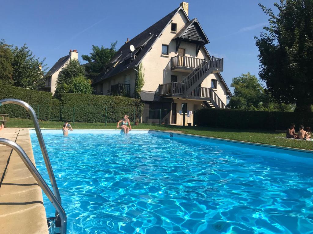 多维尔Résidence le Manoir du Mont Canisy Piscine & Tennis的房屋前的游泳池