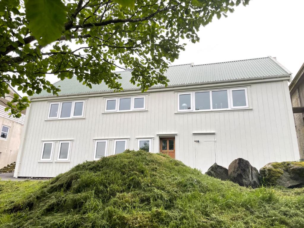 MiðvágurAbbasa hús-Grandpa s house Kumlavegur 9的一堆草顶上的白色房子