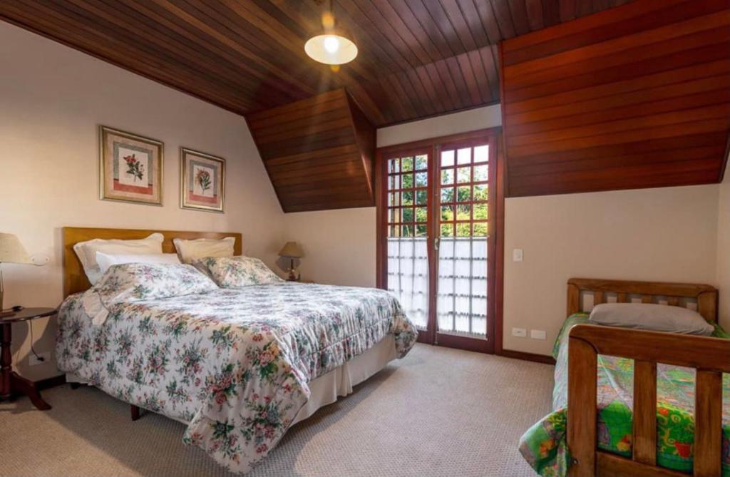 坎波斯杜若尔当Suítes Villa Panorama的一间卧室设有一张床和木制天花板