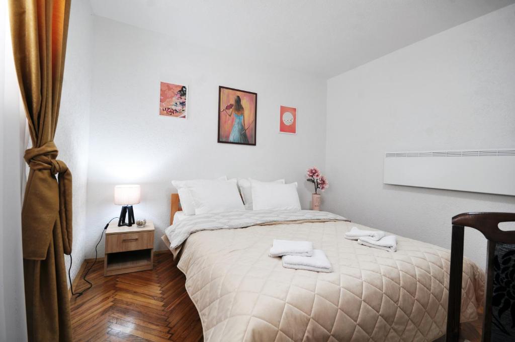 弗尔尼亚奇卡矿泉镇Stil Park Apartmani的白色卧室配有带2条毛巾的床