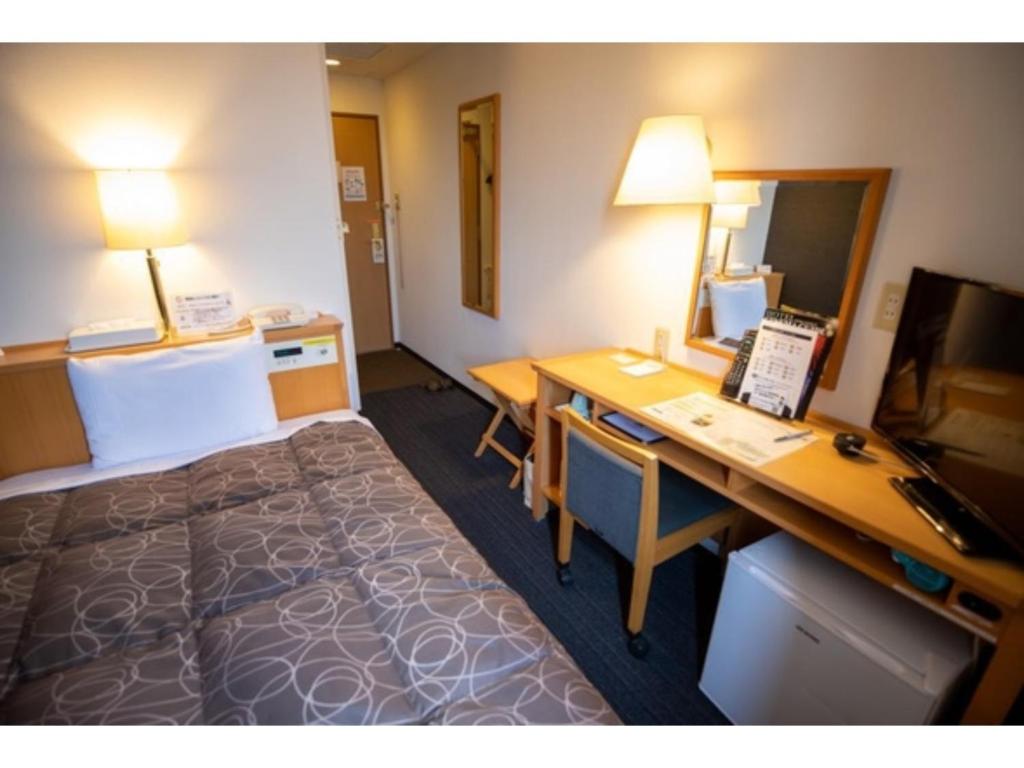 半田AZ INN HANDA INTER - Vacation STAY 69370v的酒店客房配有一张床和一张带电脑的书桌