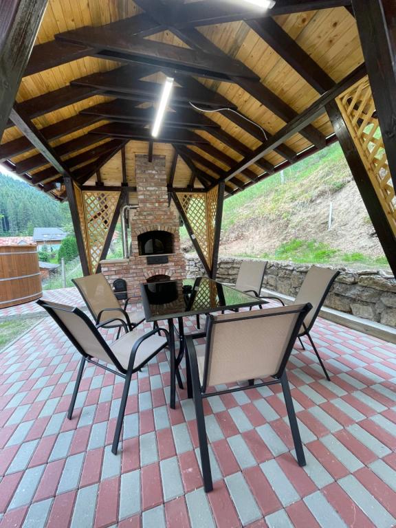 博尔塞克Casa de vacanță Cheșa的带壁炉的庭院配有桌椅