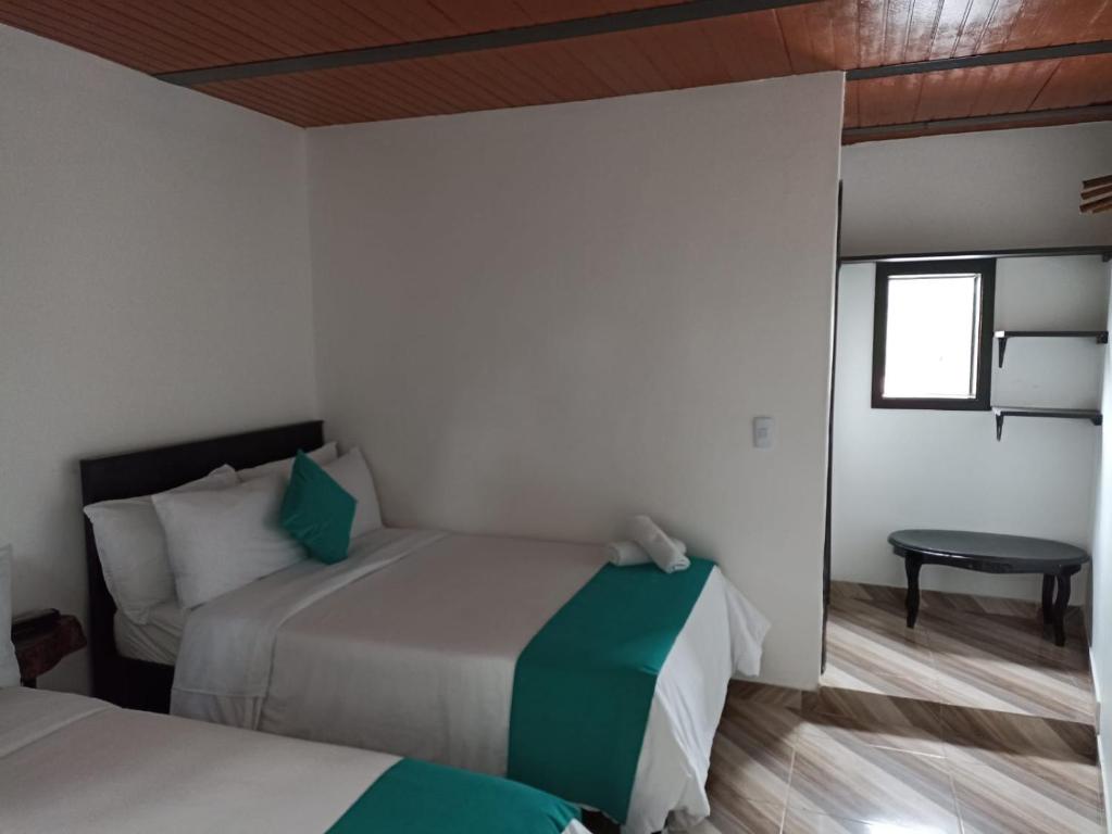 圣奥古斯丁Hotel SAMAI的一间卧室设有两张床、一张桌子和一个窗口