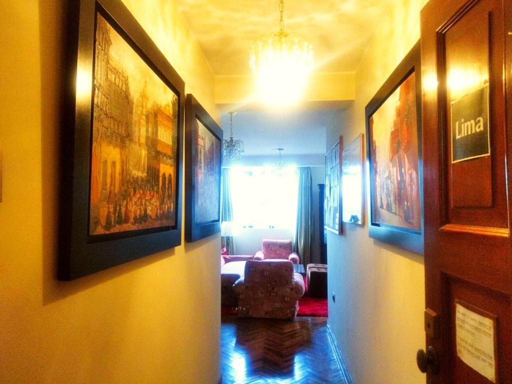 利马利马背包客旅馆的走廊上设有带椅子和绘画的客厅