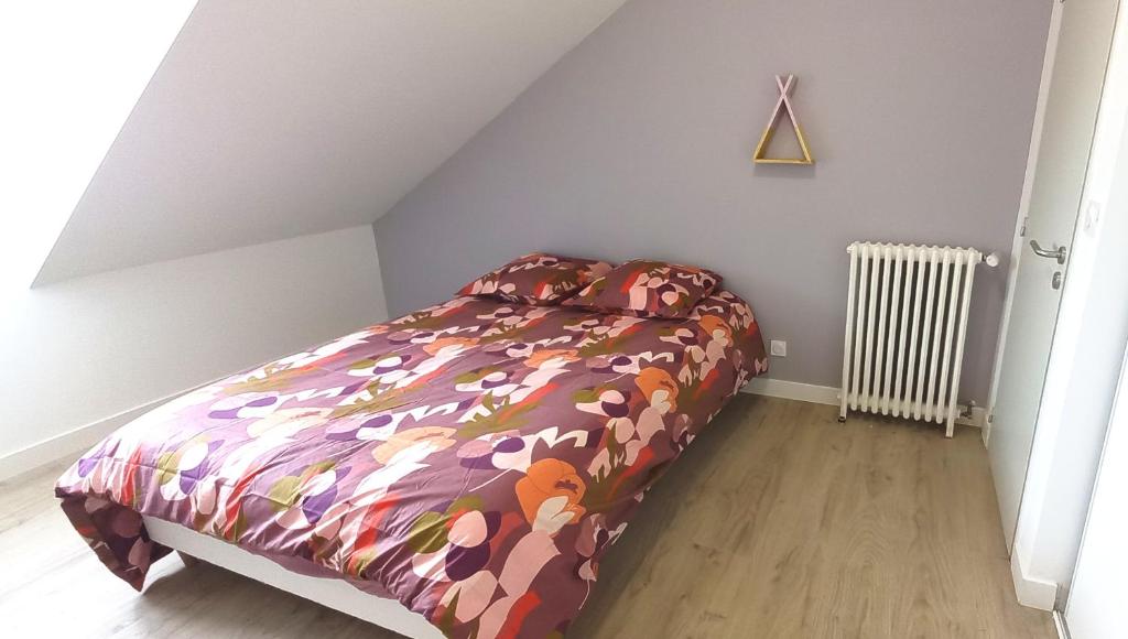索米尔Histoire de Loire - Le Futreau的一间卧室配有一张带五颜六色棉被的床