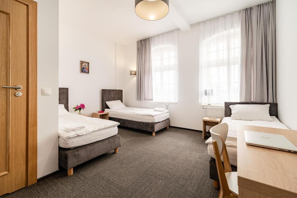 盖奇瓦乌德DOMUS MARIAE Gietrzwałd的酒店客房配有两张床和一张书桌