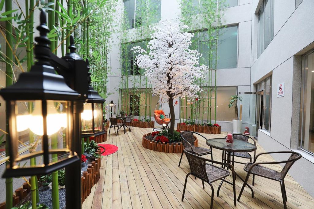 平昌玛茹酒店的一座庭院,里面设有桌椅和一棵树