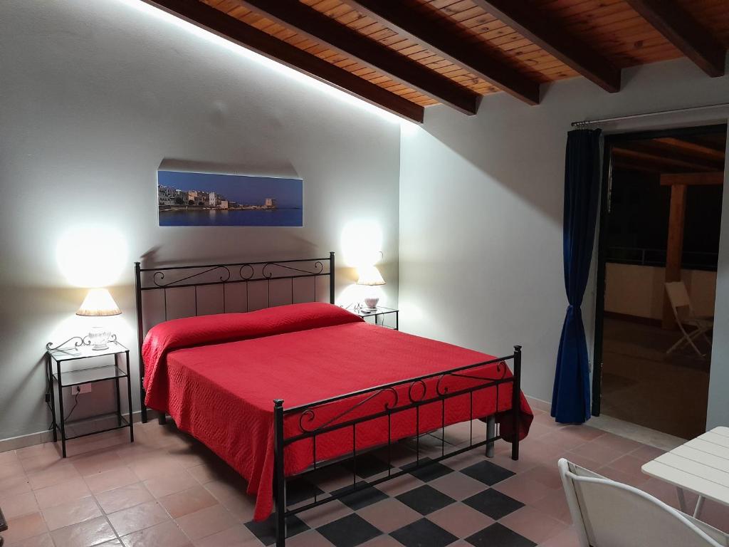 特拉帕尼Case Vacanze "Residenze Trapanesi"的一间卧室配有红色的床和红色毯子