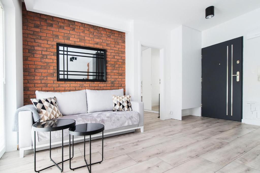 奥尔什丁Apartment City Centre Netflix- GreenPark - River的带沙发和砖墙的客厅