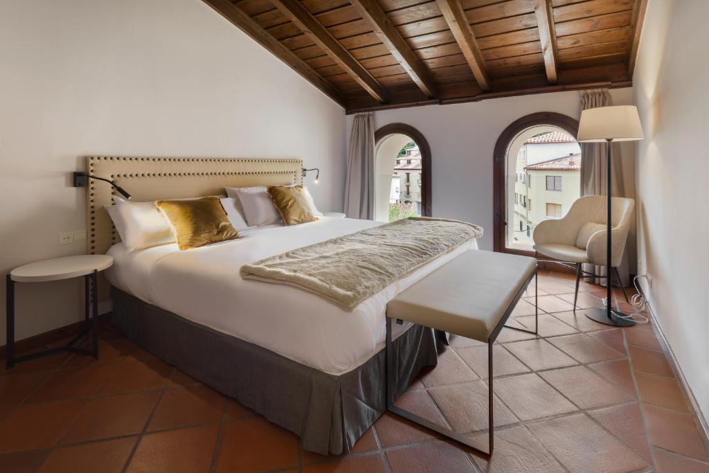 莱格莱苏埃拉德尔西德Hotel Restaurante & Spa Palacio Matutano-Daudén的卧室配有床、椅子和窗户。
