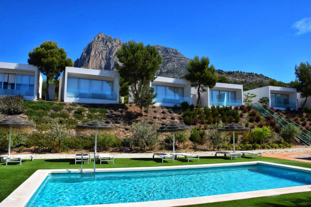 菲内斯特拉特Nature Suites Puig Campana by AR Hotels & Resorts的度假村前带游泳池的别墅