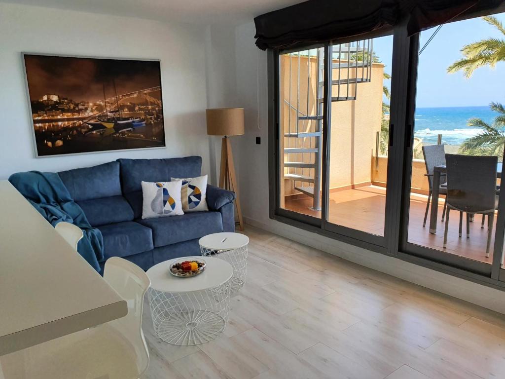 比利亚里科斯Áticos Cala Verde Playa的客厅配有蓝色的沙发和桌子