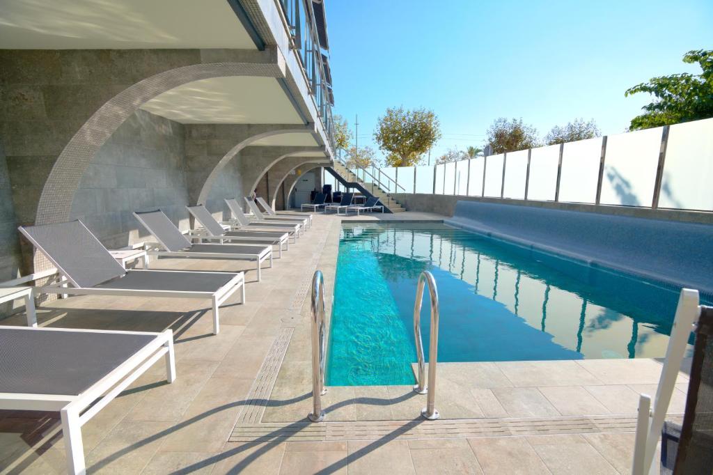 卡里拉因特纳克纳尔酒店的一座带躺椅的游泳池位于大楼旁