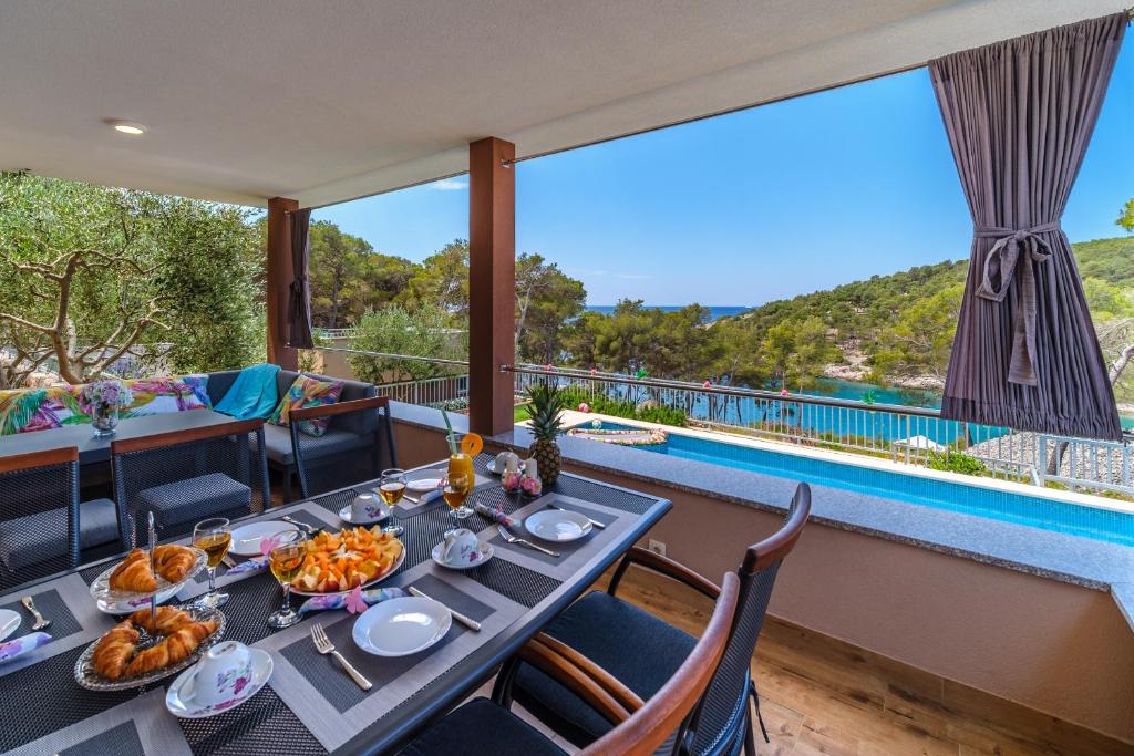 米欧纳Villa Karmelota的一间设有桌子并享有游泳池景致的用餐室