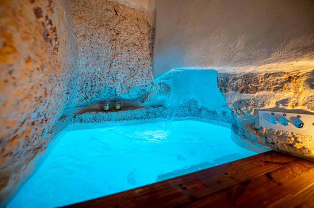 奥斯图尼AROMA luxury的石头浴缸里的蓝色水池