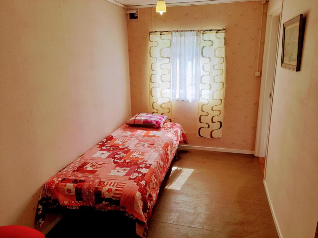 BräckeSingle bedroom, outside toilet, shower, kitchen. 120 m from Sandbach的小卧室配有一张带红色棉被的床和窗户