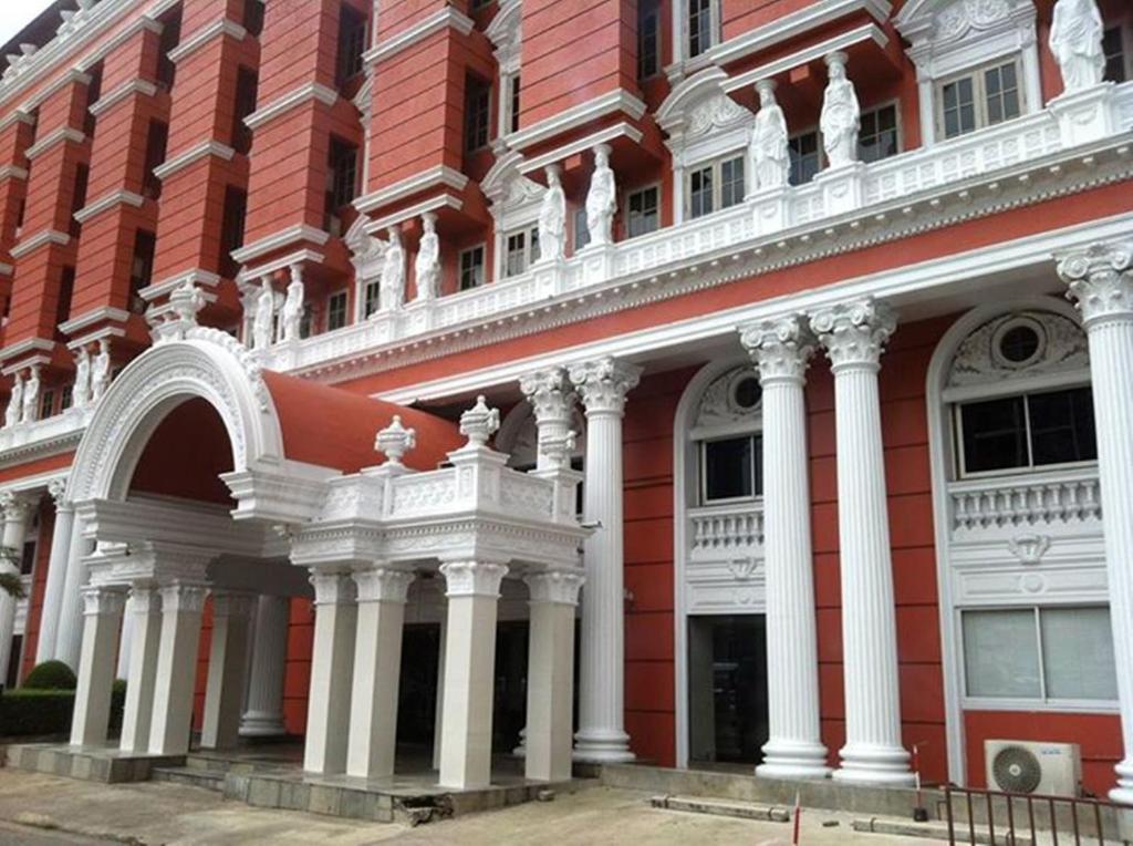 曼谷苏达宫酒店的白色的红色建筑,有白色的柱子
