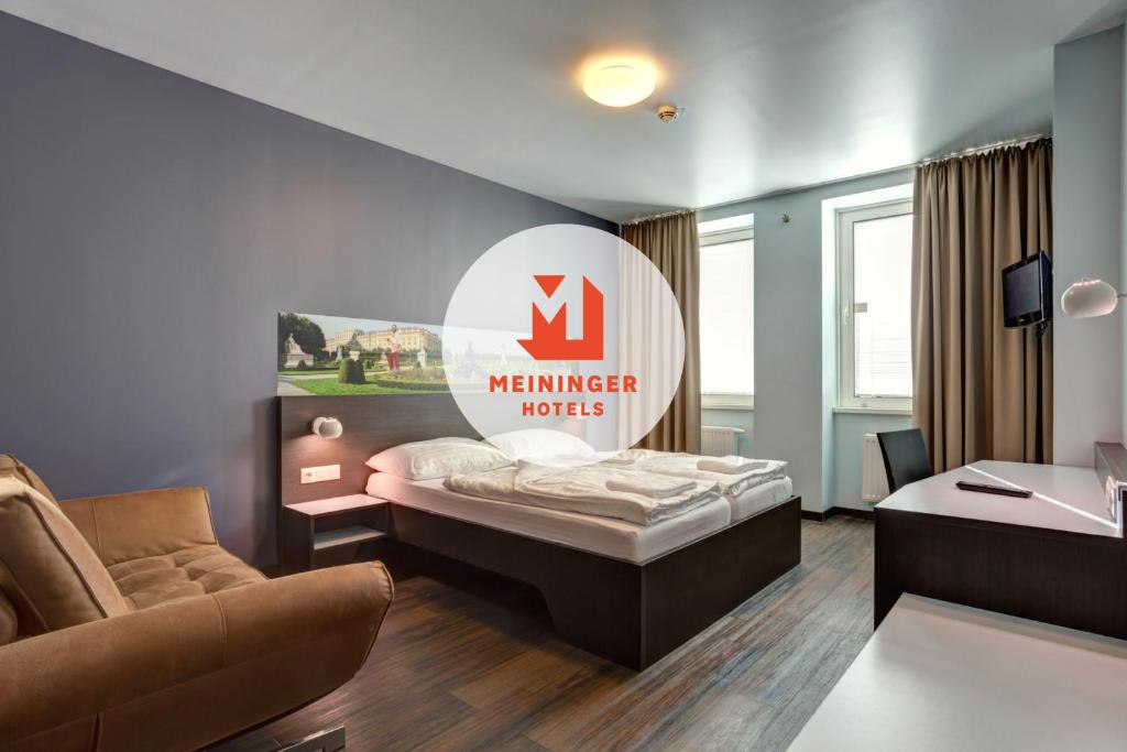 维也纳熙喜市中心梅宁阁酒店的酒店客房,设有一张床,墙上有标志