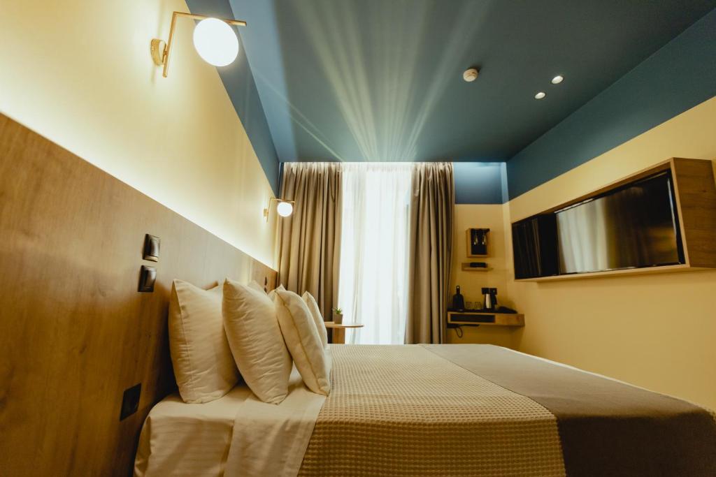 雅典Metis Urbane Living Spaces的一间卧室配有一张蓝色天花板的床