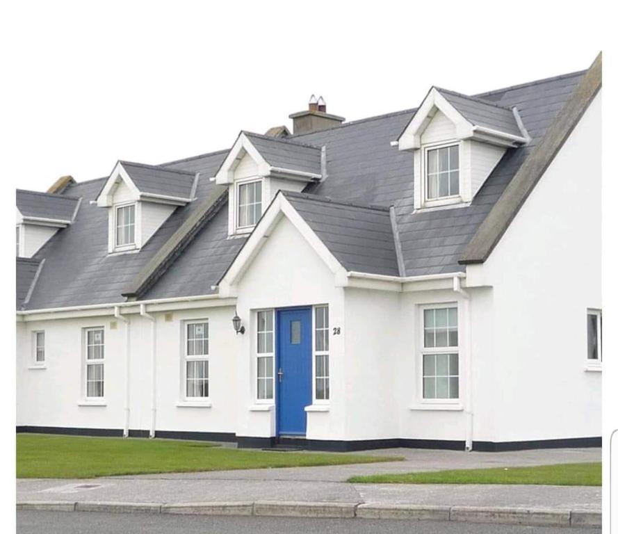巴利巴宁20 Holiday Cottage, East End Ballybunion的白色的房子,有蓝色的门