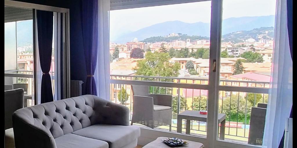 布雷西亚SUITE PANORAMA的带沙发和大窗户的客厅