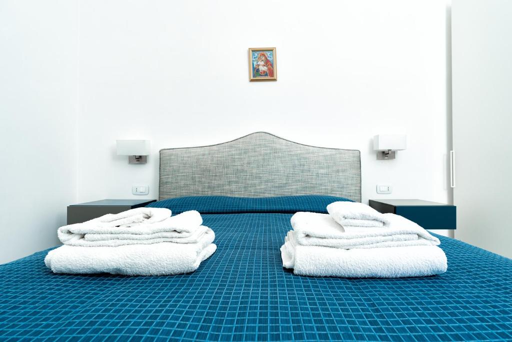 阿马尔菲La Finestra sul Corso的一间卧室配有蓝色的床和白色毛巾