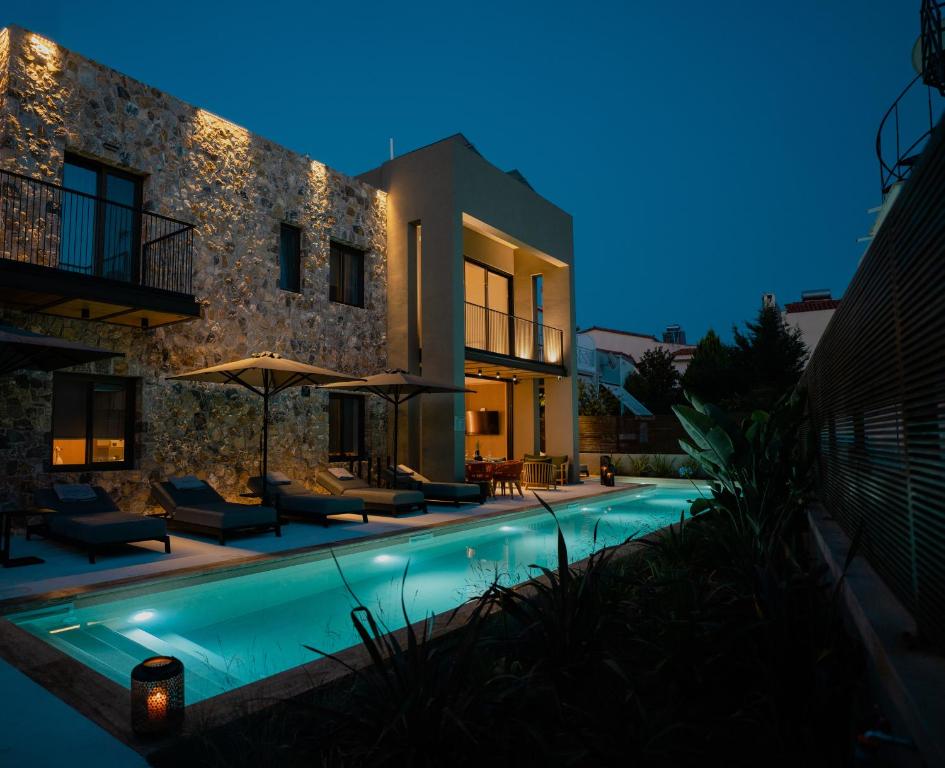 纳夫普利翁Capital Luxury Suites的夜间带游泳池的别墅
