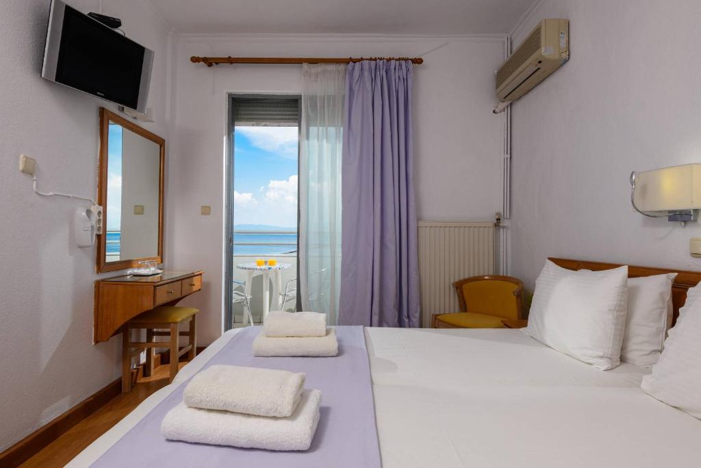 萨索斯POSSIDON HOTEL的一间卧室设有一张床,享有海景