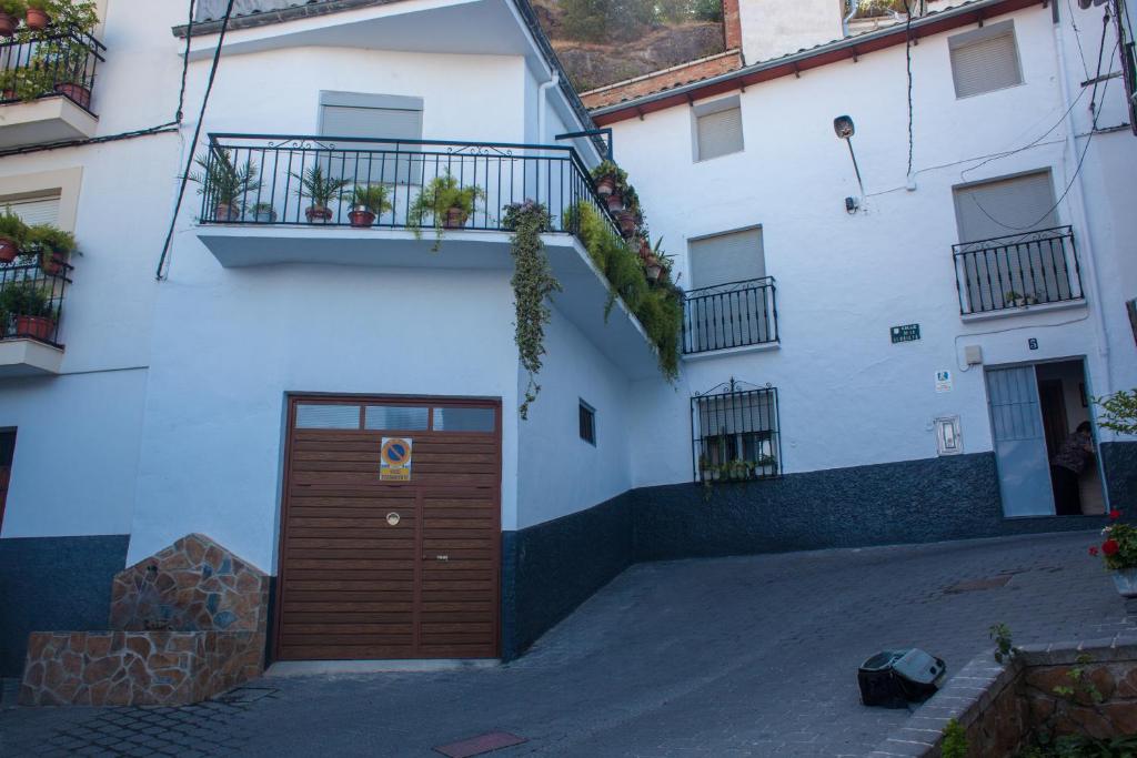 卡索拉Casa Rural José María的白色的建筑,设有棕色的门和阳台