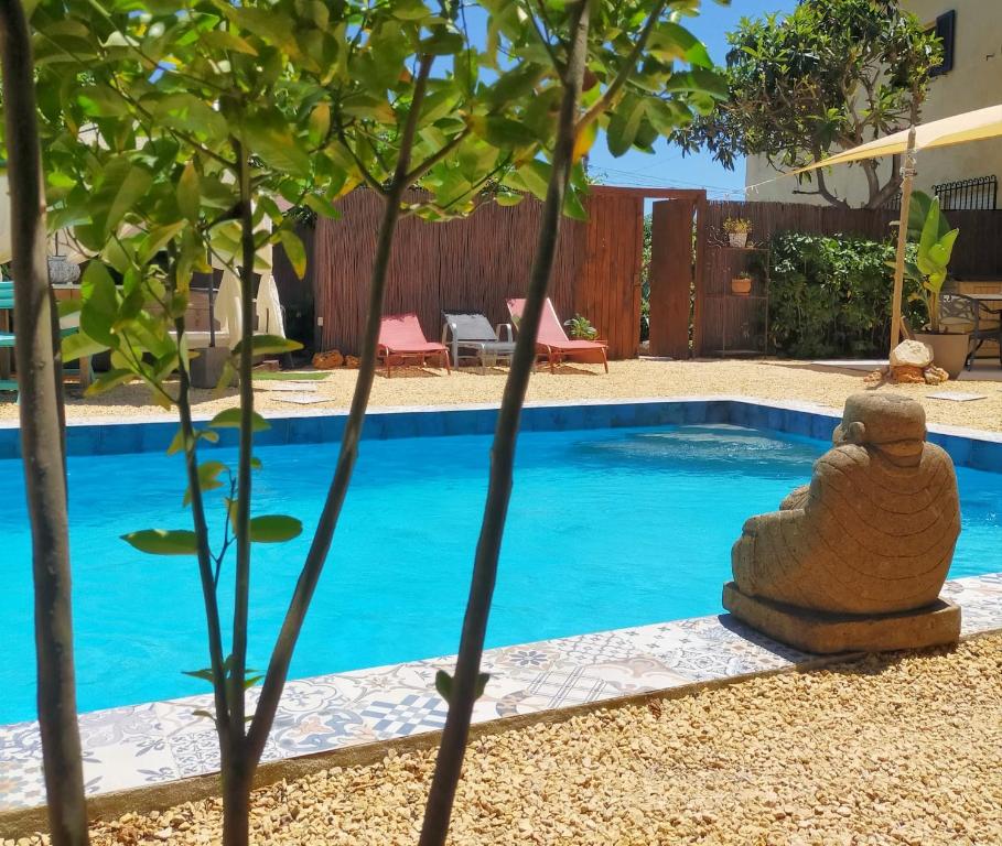 阿尔啼Casa Francesca Altea piscina y aparcamiento privado的一座游泳池,旁边是一座树,上面有石雕