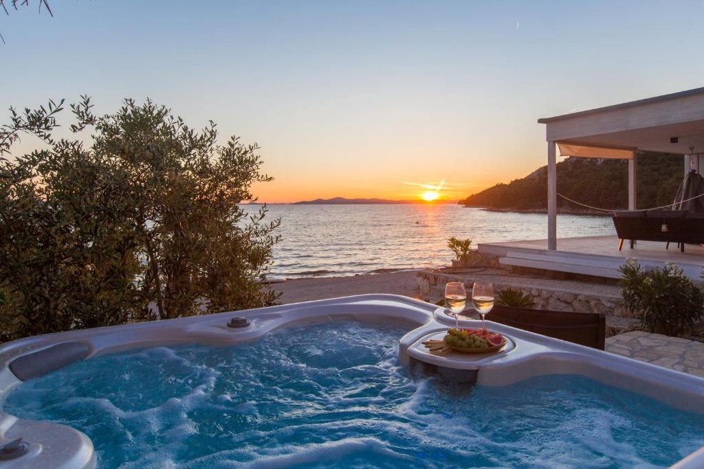 德拉格Luxury Home Buqez No 18的按摩浴缸,背面是日落
