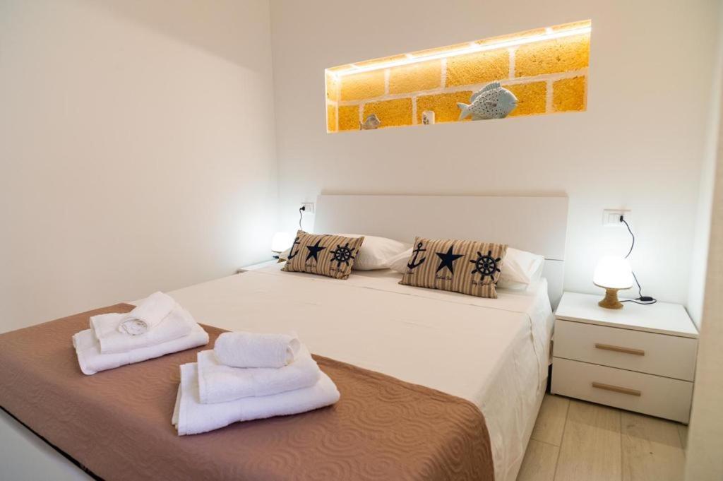 马里迪莫Casa della barchetta rossa的一间白色卧室,床上配有2条毛巾