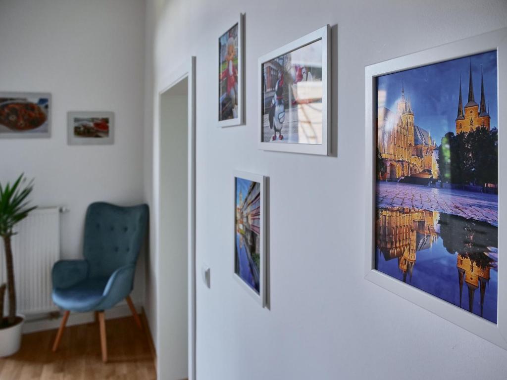 爱尔福特Appartement SCHILLER I - Erfurt Zentrum的走廊上设有蓝色椅子,墙上挂有图片