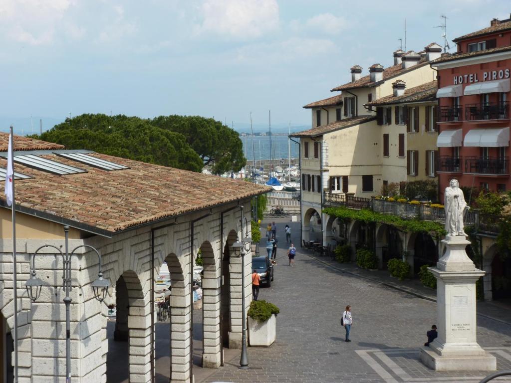 代森扎诺-德尔加达Appartamento palazzo del Provveditore vista lago的城镇中拥有建筑和雕像的街道