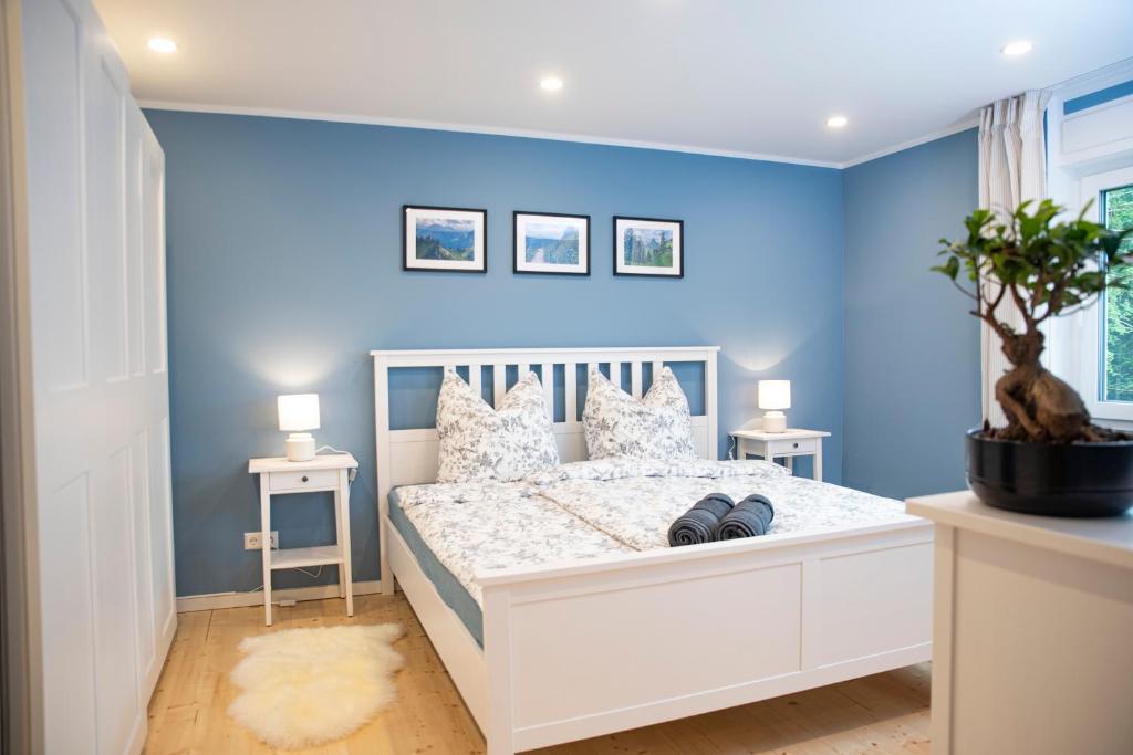 多瑙艾辛根Moderne Wohnung im Grünen mit privatem Garten的卧室拥有蓝色的墙壁和白色的床。