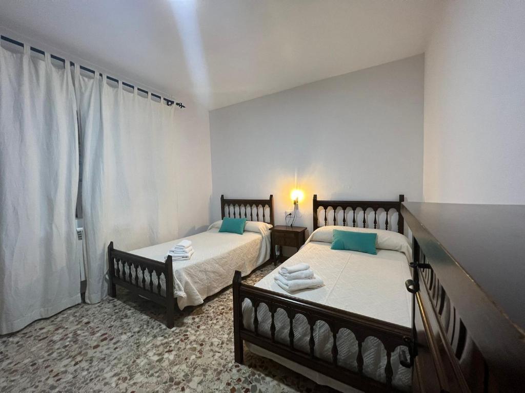 卡韦苏埃拉德尔瓦列Apartamentos Lalola的一间卧室设有两张床和窗户。