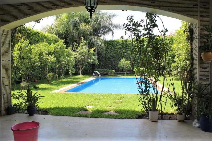 马拉喀什Magnifique villa avec piscine pour famille uniquement的通往庭院游泳池的拱门