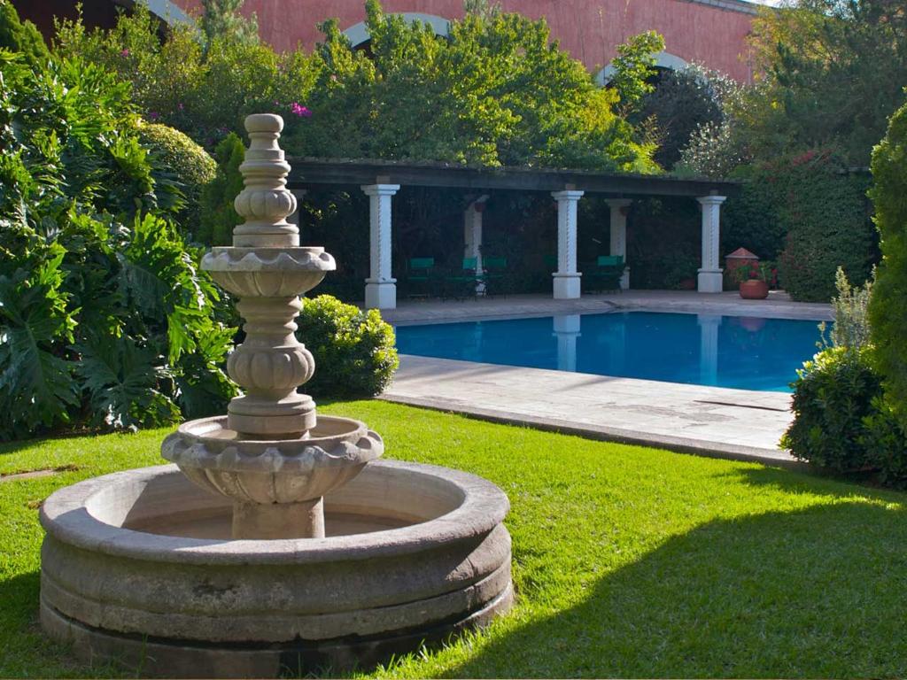 杜兰戈统治者酒店的游泳池旁草地上的石头喷泉
