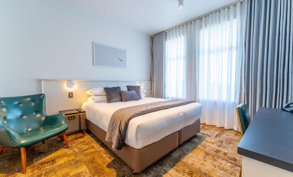 提马鲁格罗夫纳酒店 的配有一张床和一把椅子的酒店客房